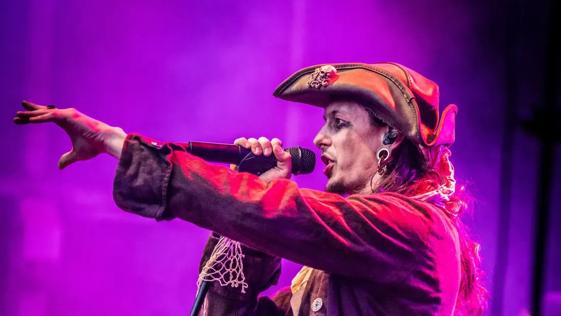 Sänger im Piratenkostüm am Mikrofon im violetten Bühnenlicht, Holtebüttel Rockt 2026