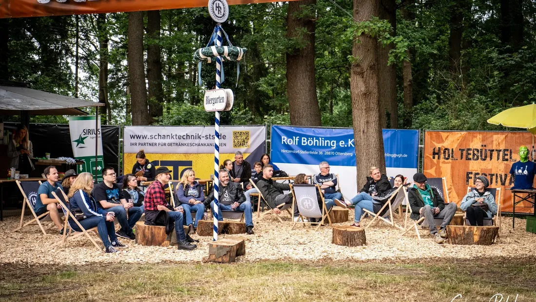 Festivalgelände mit Liegestühlen unter dem Banner „Jugendhilfe rockt“, Holtebüttel Rockt 2024