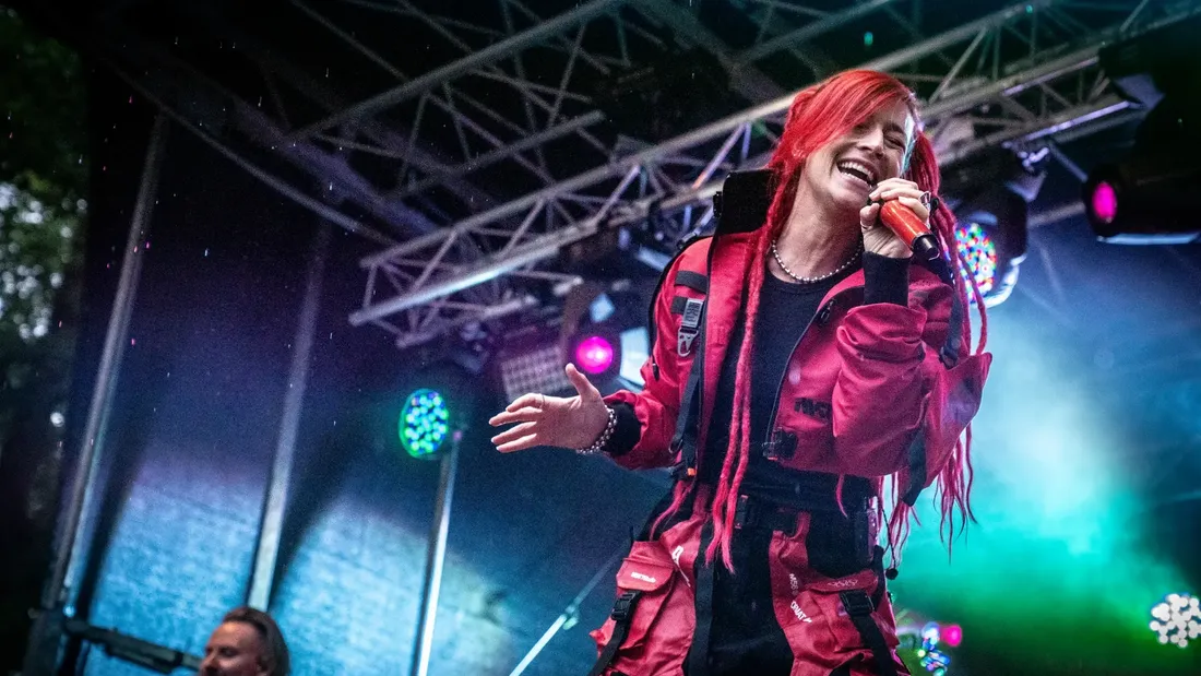 Sängerin von April Art mit roten Zöpfen am Mikrofon bei Holtebüttel Rockt 2025