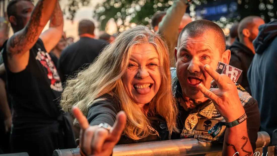 Zwei lachende Festivalgäste an der Bühnenabsperrung, Holtebüttel Rockt 2024