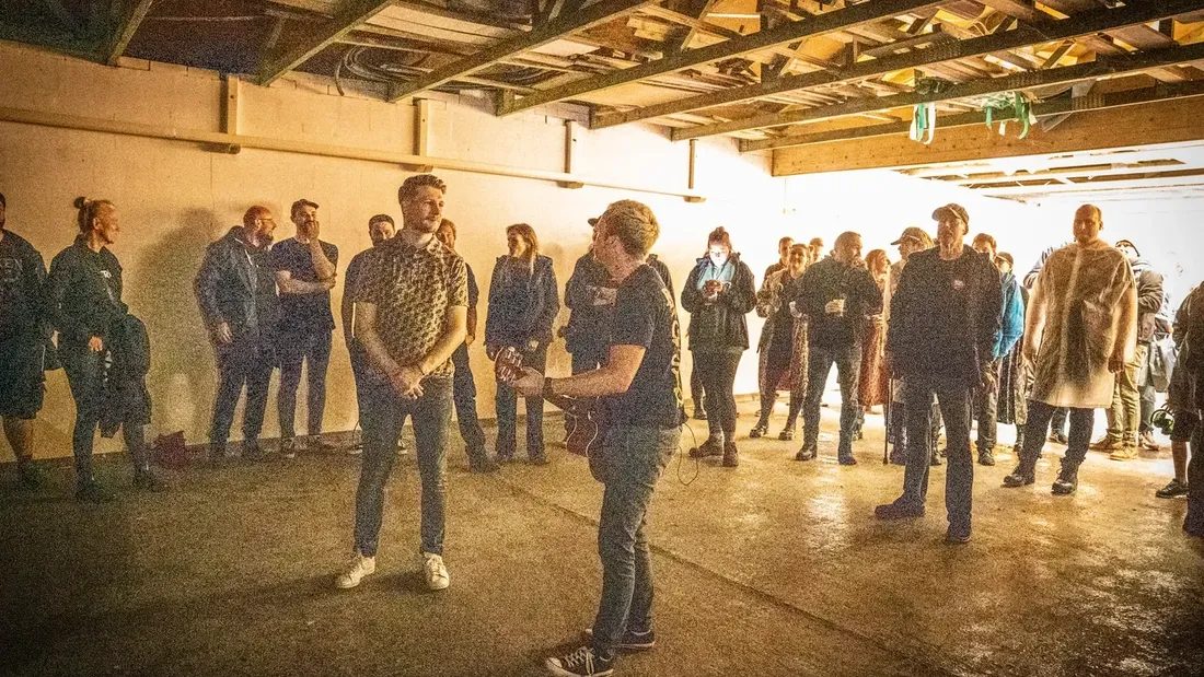 Akustikauftritt mit Gitarre vor Festivalgästen in einer Halle bei Holtebüttel Rockt 2025