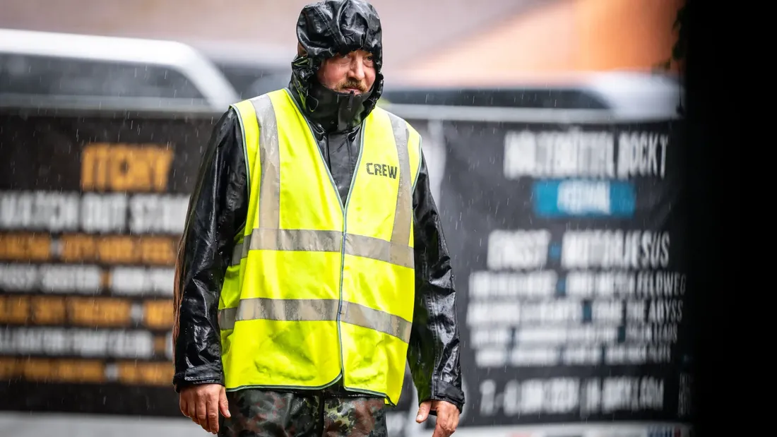 Crewmitglied mit gelber Warnweste im Regen bei Holtebüttel Rockt 2025